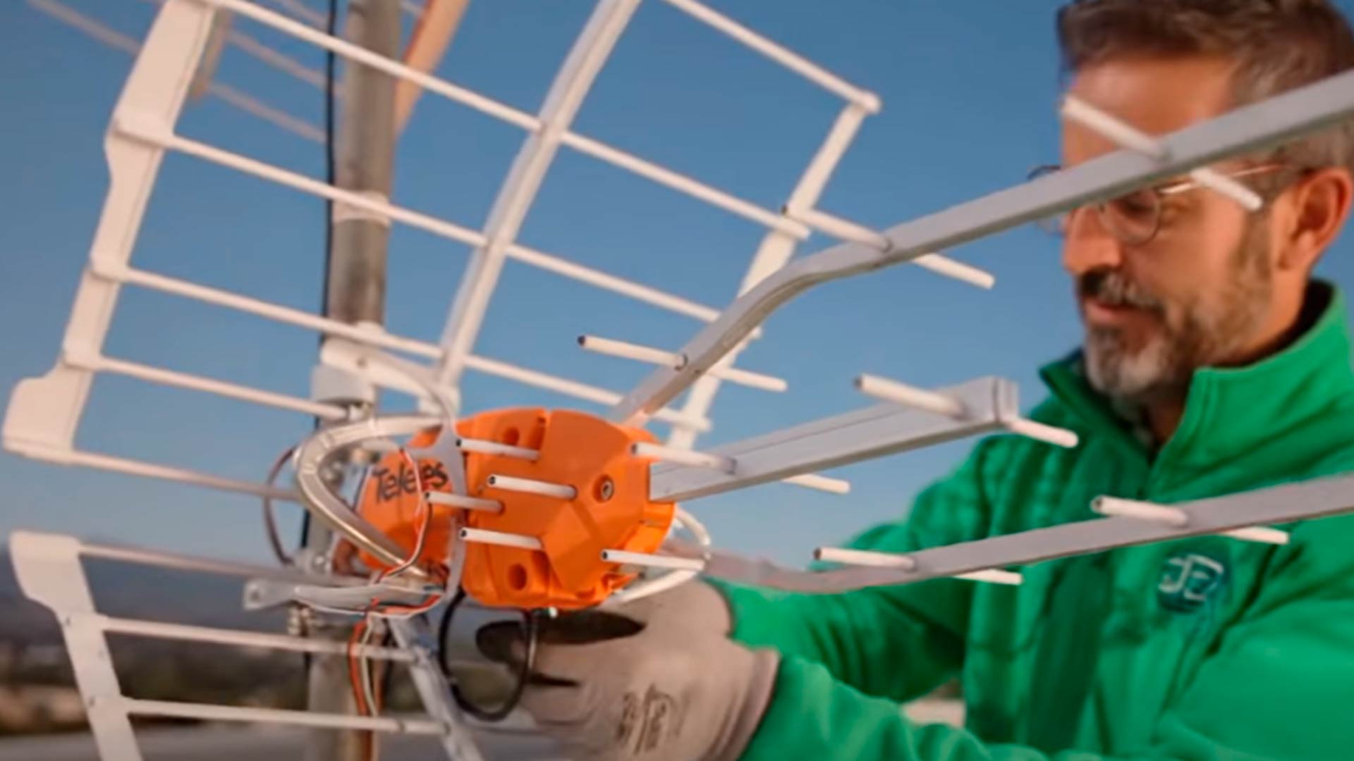Técnico instalando una antena de televisión en el tejado de un edificio